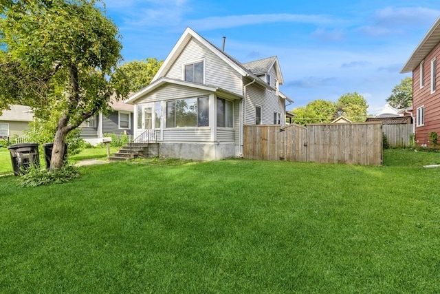 back of house with a sunroom and a yard