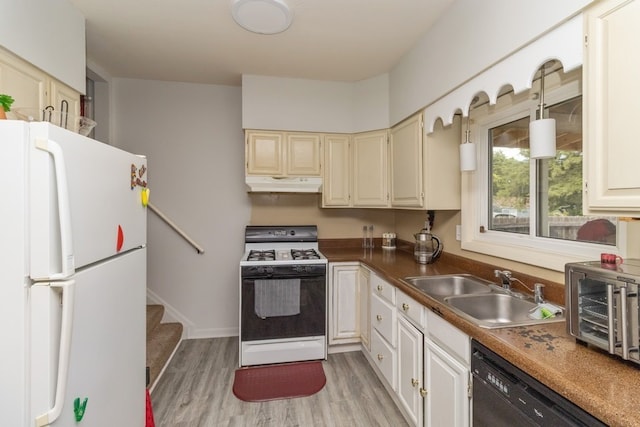 kitchen featuring pendant lighting, white appliances, sink, and light hardwood / wood-style floors