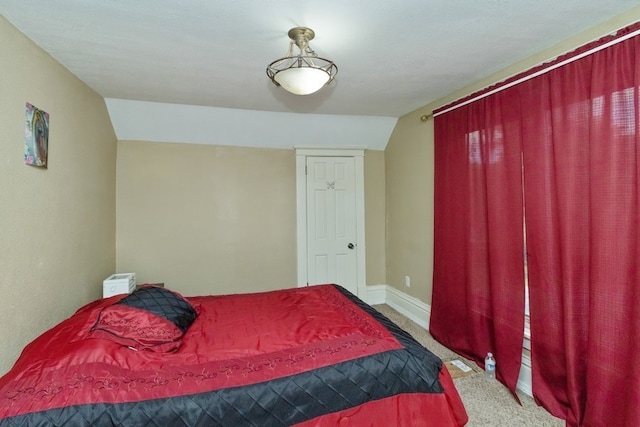 bedroom featuring lofted ceiling and carpet