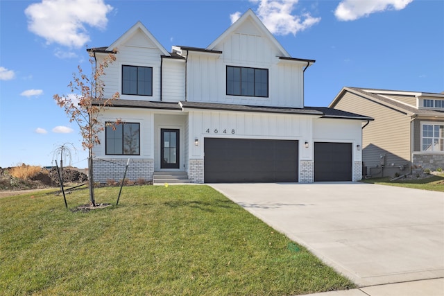 modern farmhouse with brick siding, concrete driveway, board and batten siding, and a front yard