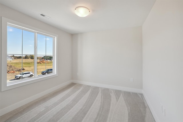 carpeted empty room featuring visible vents and baseboards