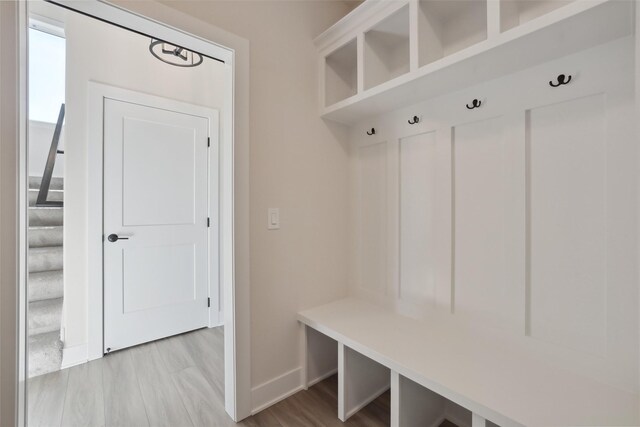 mudroom featuring light wood-type flooring and baseboards