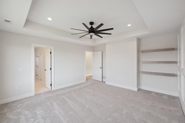 unfurnished bedroom featuring a tray ceiling, recessed lighting, visible vents, and baseboards