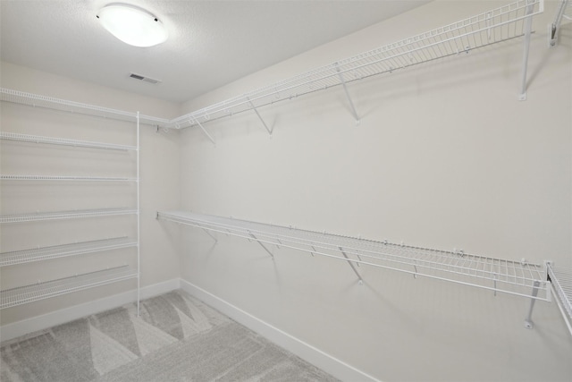 walk in closet with carpet floors and visible vents