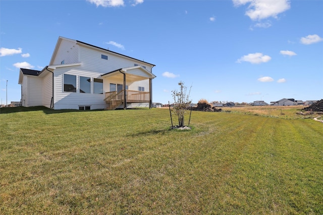 rear view of property featuring a lawn