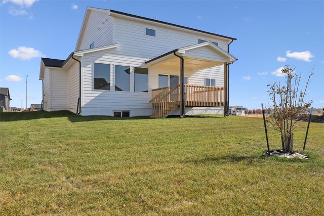 back of property with a lawn and a wooden deck