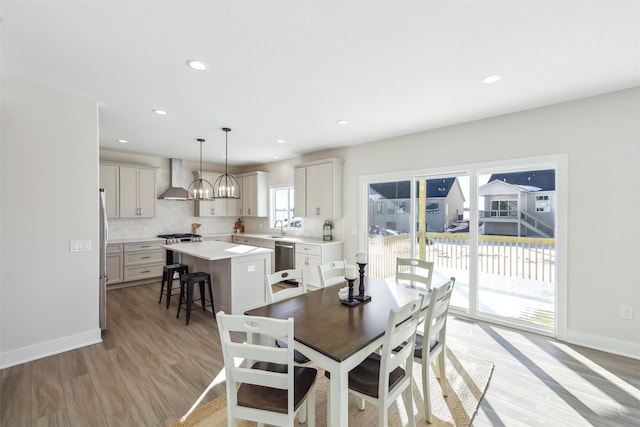 dining area with light wood finished floors, recessed lighting, an inviting chandelier, and baseboards