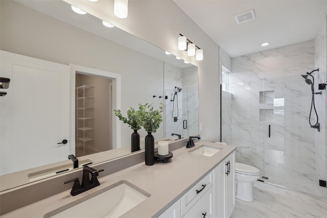 bathroom featuring vanity, a shower with shower door, and toilet