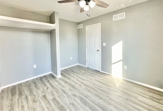 unfurnished bedroom with a closet, light wood-type flooring, and ceiling fan