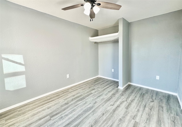 unfurnished bedroom with light hardwood / wood-style flooring, a closet, and ceiling fan