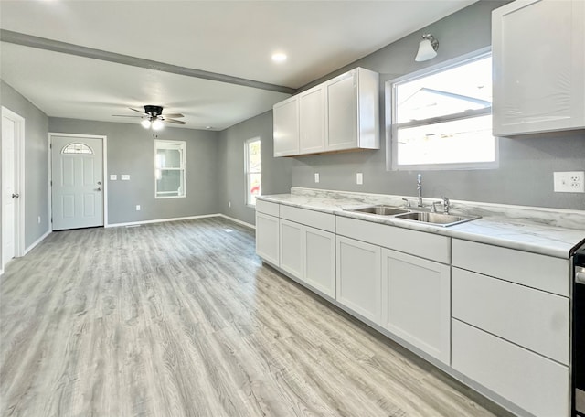 kitchen with white cabinetry, light hardwood / wood-style flooring, sink, and plenty of natural light