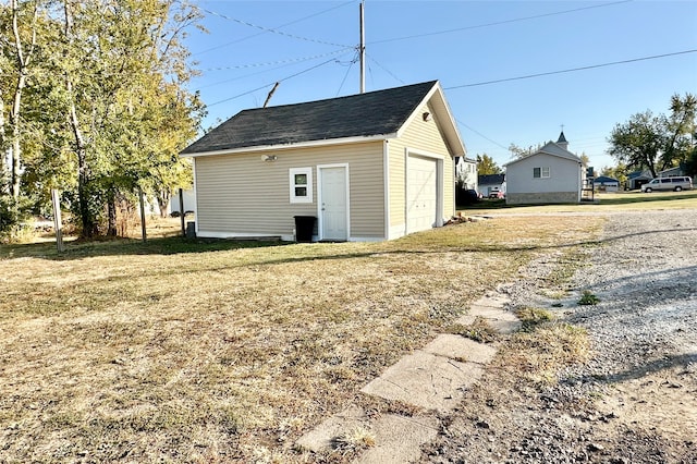 view of outbuilding with a garage and a lawn