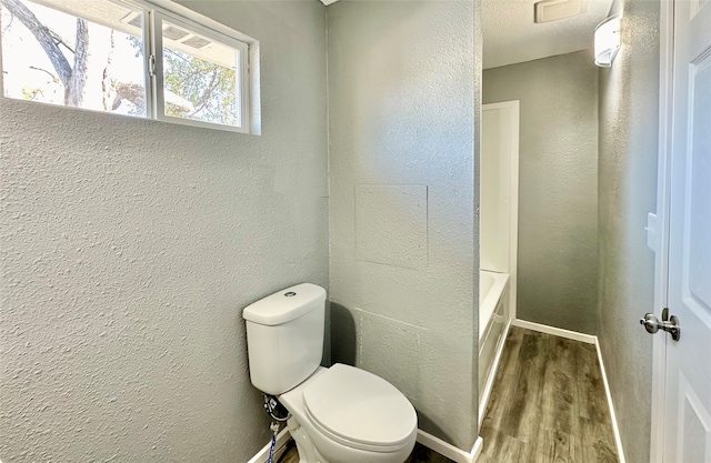 bathroom featuring toilet, shower with separate bathtub, and hardwood / wood-style flooring