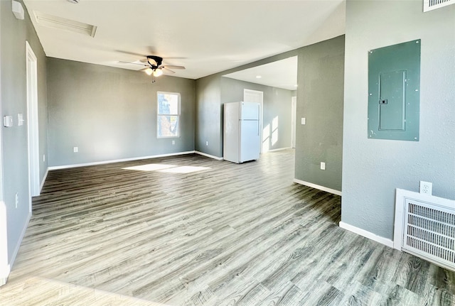 unfurnished room with electric panel, light wood-type flooring, and ceiling fan