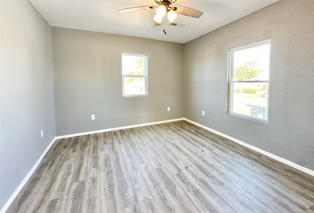 unfurnished room with light wood-type flooring, plenty of natural light, and ceiling fan