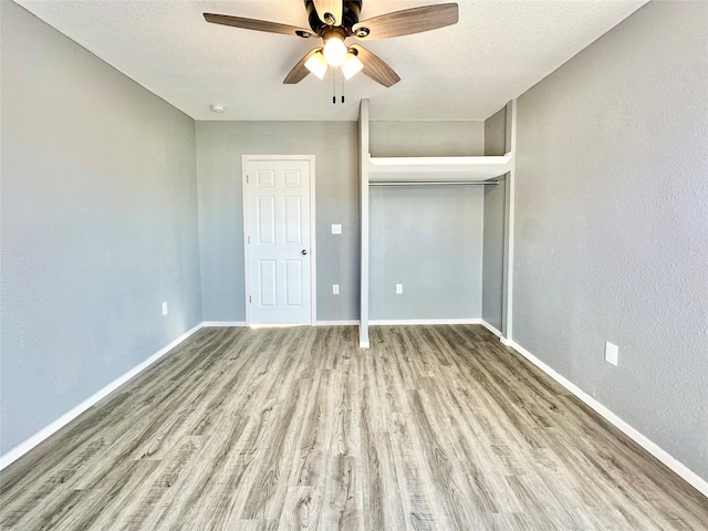 unfurnished bedroom with light hardwood / wood-style flooring, a textured ceiling, a closet, and ceiling fan