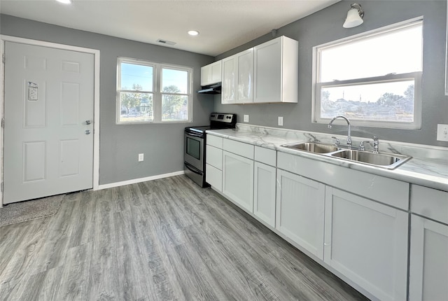 kitchen featuring sink, stainless steel range with electric cooktop, white cabinetry, light hardwood / wood-style floors, and light stone counters