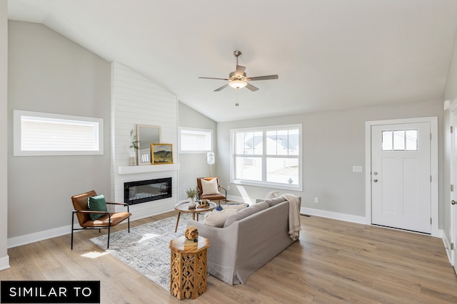 living room with light hardwood / wood-style flooring, high vaulted ceiling, a fireplace, and ceiling fan