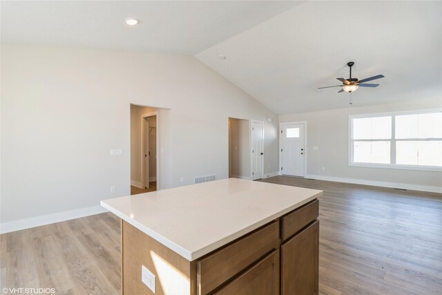 kitchen featuring light wood finished floors, open floor plan, light countertops, and a center island