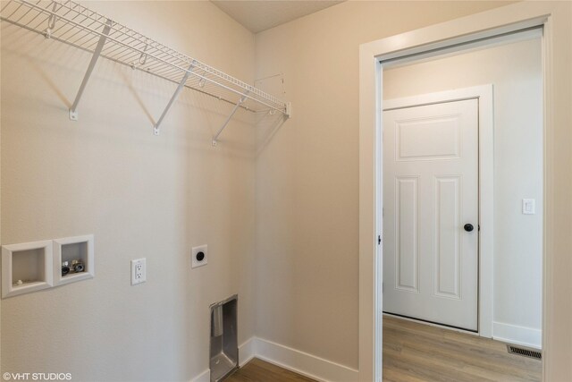 laundry area featuring hookup for a washing machine, hookup for an electric dryer, wood finished floors, laundry area, and baseboards