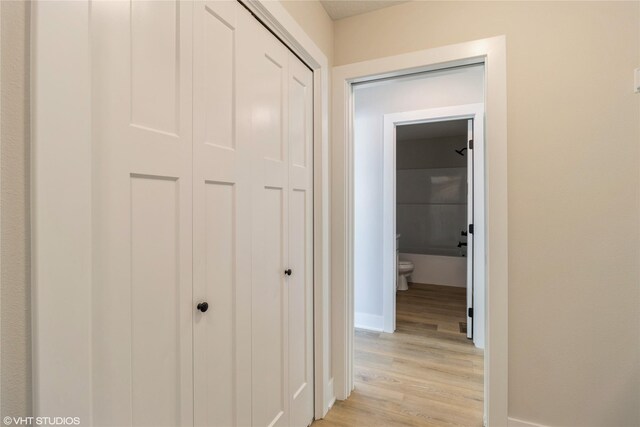 hallway with light wood-style floors and baseboards