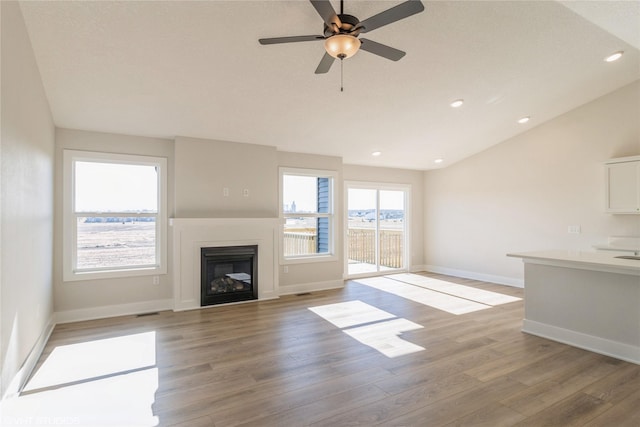 unfurnished living room with ceiling fan, lofted ceiling, and light hardwood / wood-style floors