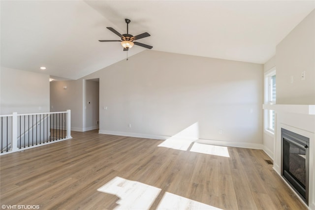 unfurnished living room with lofted ceiling, ceiling fan, and light hardwood / wood-style flooring