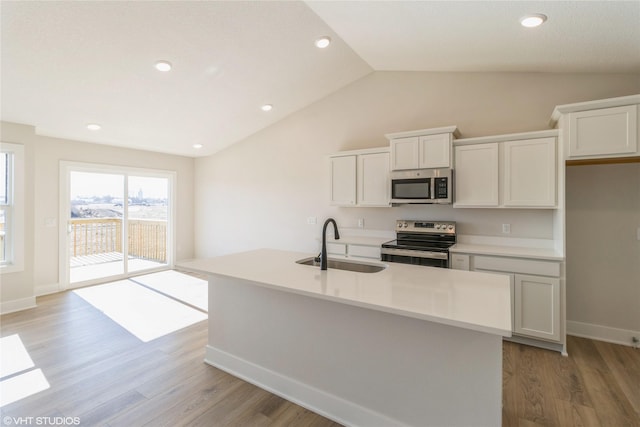 kitchen featuring white cabinetry, stainless steel appliances, sink, and an island with sink