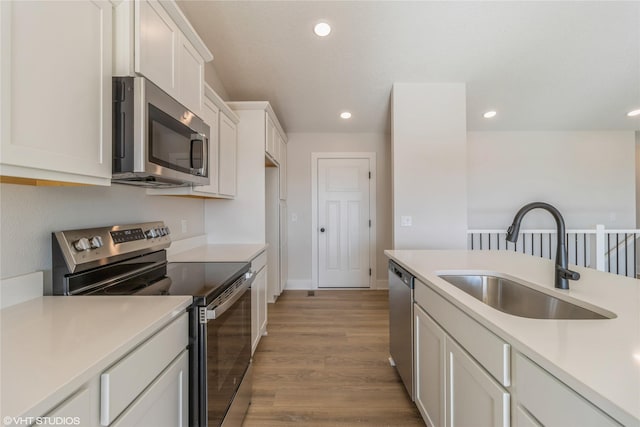 kitchen featuring white cabinetry, appliances with stainless steel finishes, sink, and light wood-type flooring