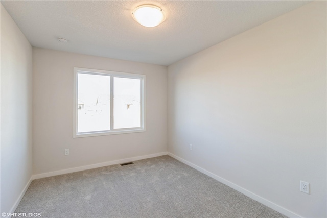 spare room with carpet and a textured ceiling