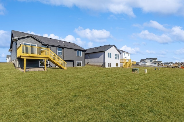 back of property with a wooden deck and a yard