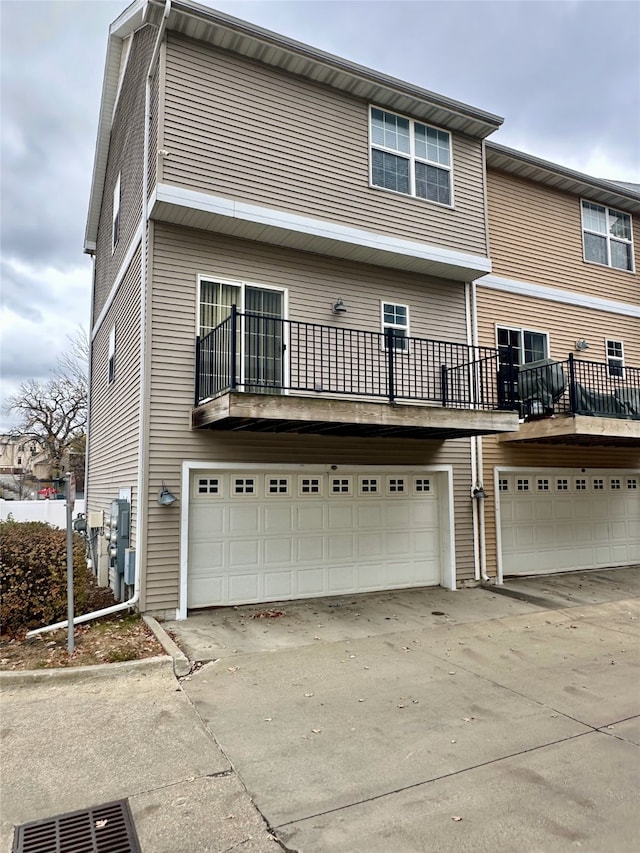 back of property with a balcony and a garage