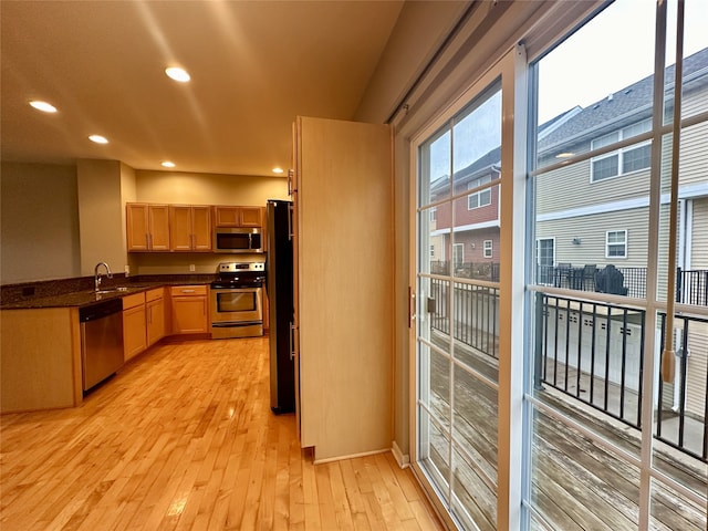 kitchen featuring appliances with stainless steel finishes, light brown cabinets, sink, and light hardwood / wood-style floors