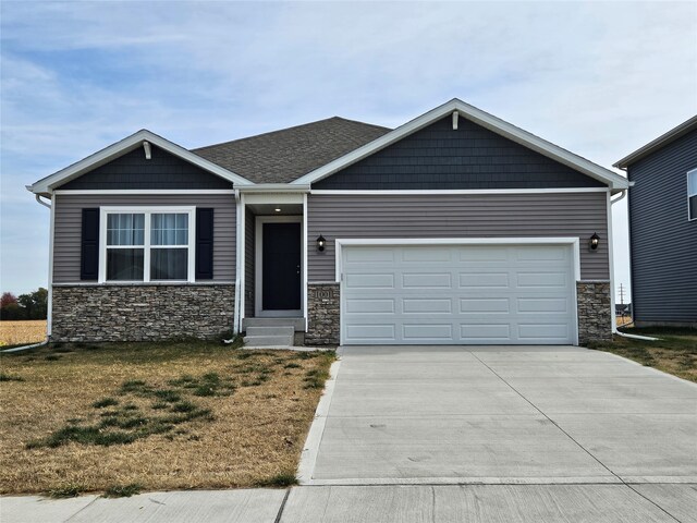 craftsman inspired home featuring a garage and a front lawn