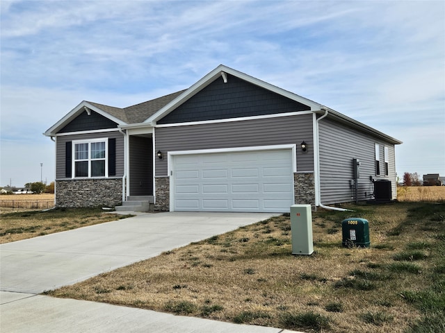 view of front of home with central AC, a garage, and a front yard