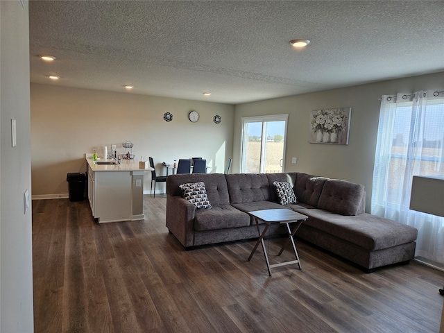 living room featuring a textured ceiling and dark wood-type flooring