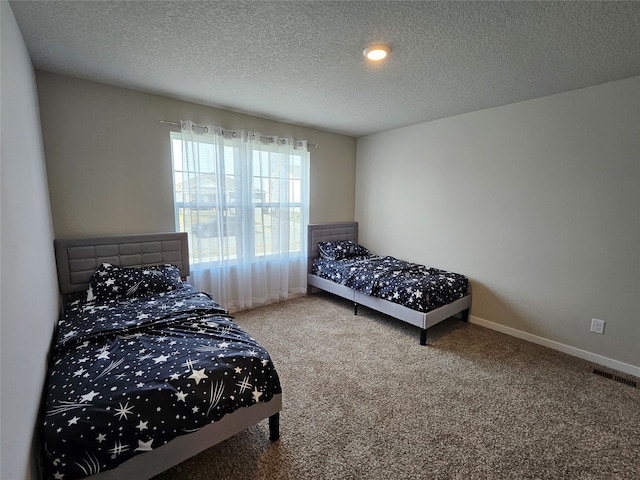 bedroom featuring a textured ceiling and carpet floors