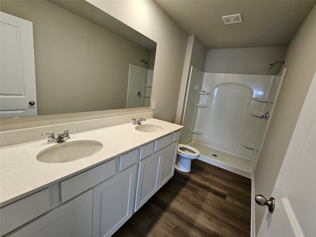 bathroom featuring toilet, walk in shower, vanity, and wood-type flooring