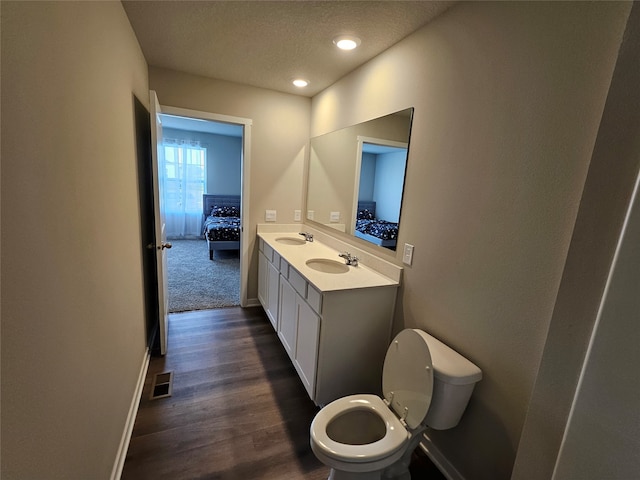 bathroom featuring vanity, toilet, a textured ceiling, and hardwood / wood-style floors