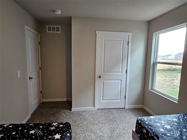 unfurnished bedroom featuring a textured ceiling and carpet floors