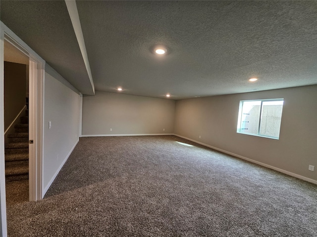 carpeted empty room with a textured ceiling