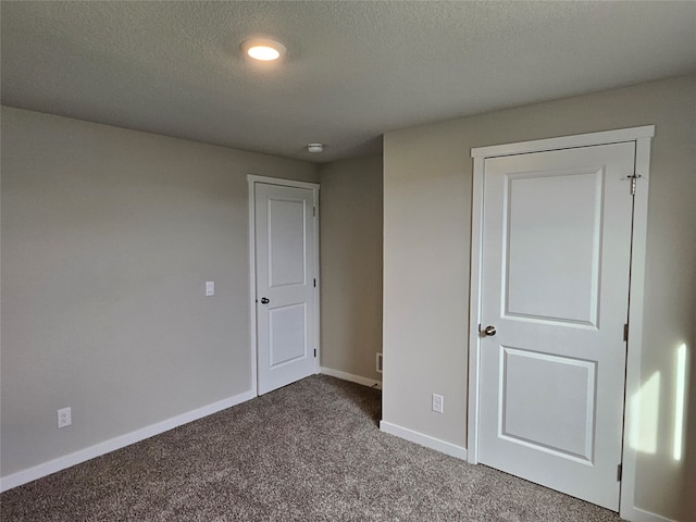 unfurnished bedroom with a textured ceiling and carpet floors