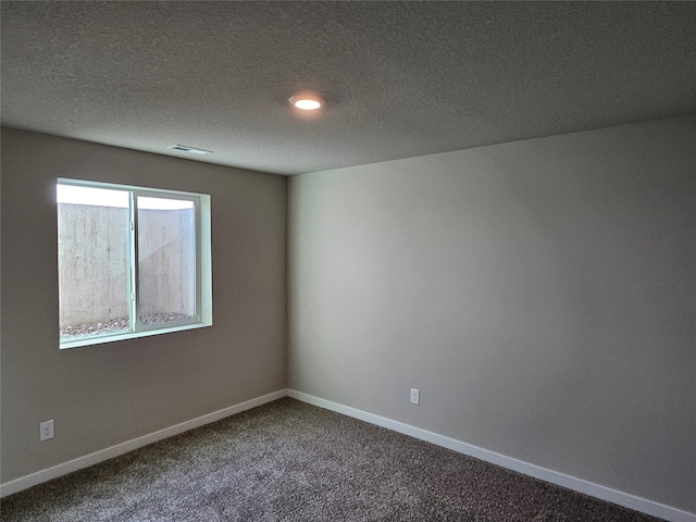 unfurnished room with a textured ceiling and carpet flooring