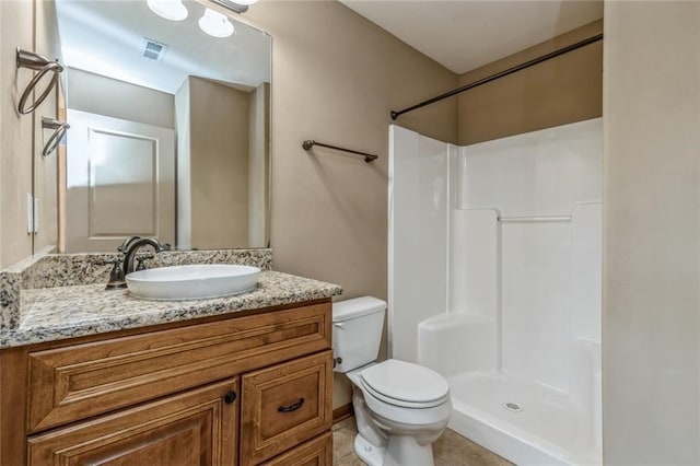 bathroom featuring toilet, walk in shower, vanity, and tile patterned flooring