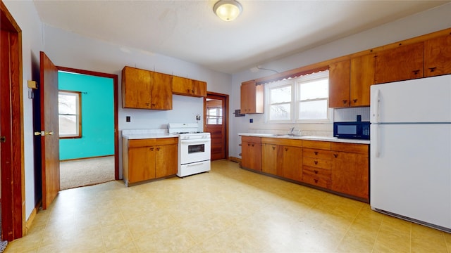 kitchen featuring a healthy amount of sunlight, white appliances, and sink