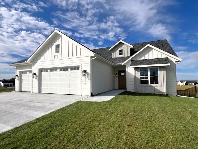 modern farmhouse featuring a garage and a front yard