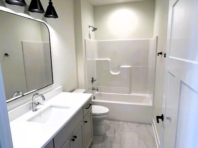 full bathroom featuring washtub / shower combination, vanity, and toilet