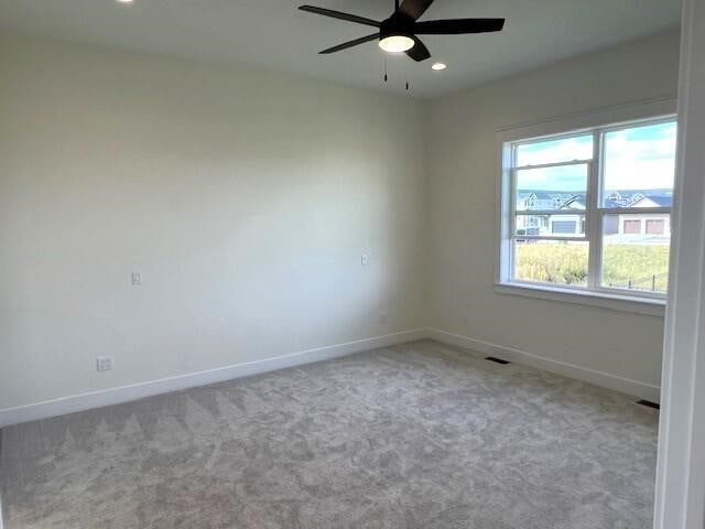 carpeted empty room featuring ceiling fan