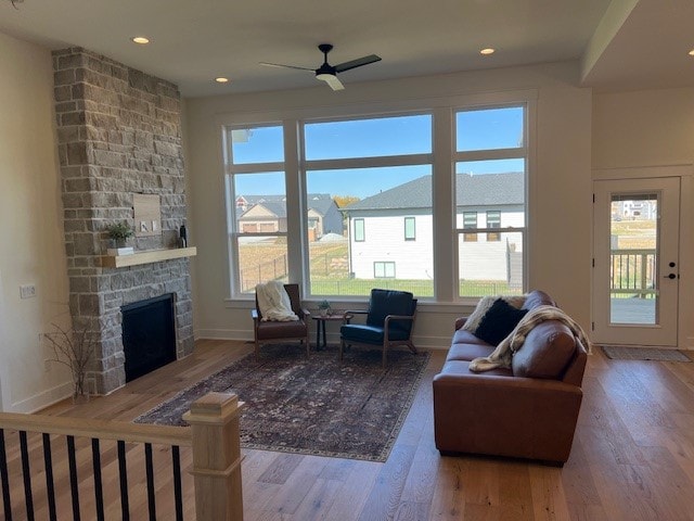 living room featuring wood-type flooring, a healthy amount of sunlight, and a fireplace