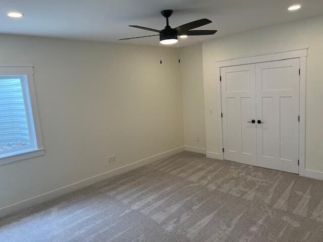 unfurnished bedroom featuring a closet, carpet flooring, and ceiling fan